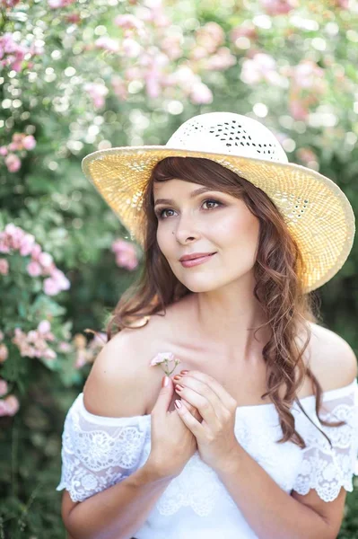 Genç güzel kadın çiçekli parkta yürüyor. Genç bir kadın portresi. Mutlu kız. Yaz.