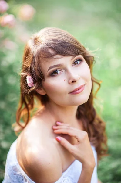 Mladá krásná žena chodí v květinovém parku. Portrét mladé ženy. Šťastná dívka. Léto. — Stock fotografie