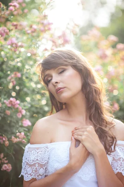 Jeune belle femme se promène dans le parc fleuri. Portrait d'une jeune femme. Bonne fille. Été . — Photo