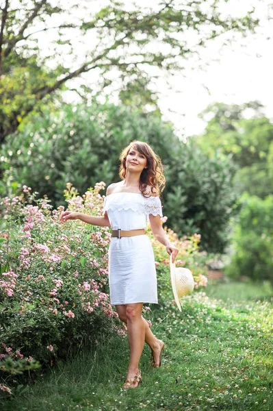 Jovem mulher bonita caminha no parque florido. Retrato de uma jovem. Menina feliz. Verão . — Fotografia de Stock