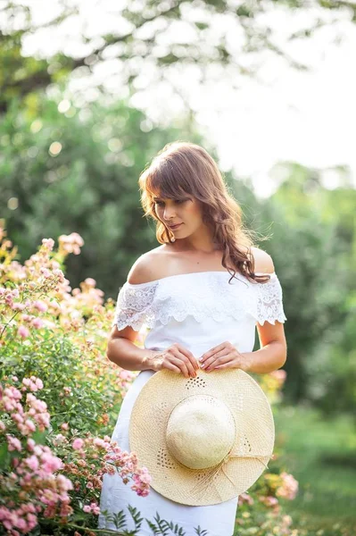 Mladá krásná žena chodí v květinovém parku. Portrét mladé ženy. Šťastná dívka. Léto. — Stock fotografie