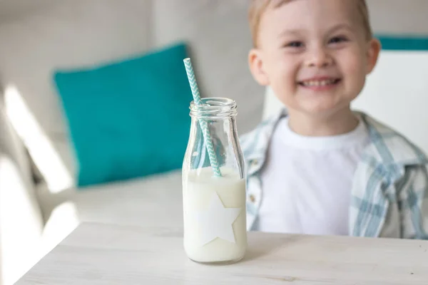 かわいい男の子はキャンディを食べる、牛乳を飲みます。健康。幸せな子。朝食。小さな男の子はテーブルに座っています。. — ストック写真