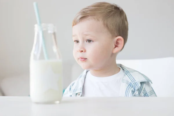 かわいい男の子はキャンディを食べる、牛乳を飲みます。健康。幸せな子。朝食。小さな男の子はテーブルに座っています。. — ストック写真