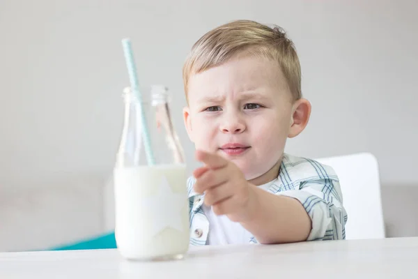 かわいい男の子はキャンディを食べる、牛乳を飲みます。健康。幸せな子。朝食。小さな男の子はテーブルに座っています。. — ストック写真