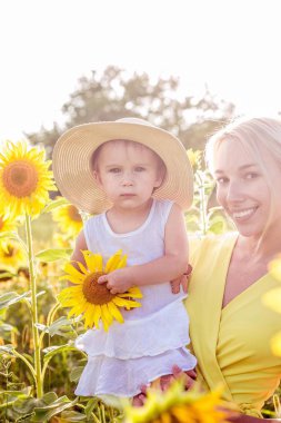 Aile alan çiçeklenme yaz yürüyor. Mutlu anne ve kızı güneş. Yaz. Ayçiçeği.