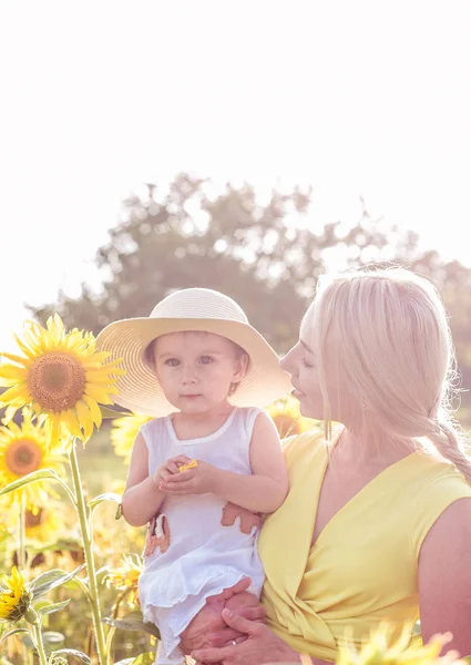 Aile alan çiçeklenme yaz yürüyor. Mutlu anne ve kızı güneş. Yaz. Ayçiçeği. — Stok fotoğraf