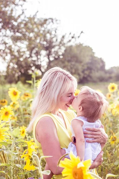 Aile alan çiçeklenme yaz yürüyor. Mutlu anne ve kızı güneş. Yaz. Ayçiçeği. — Stok fotoğraf