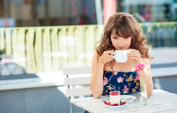 Güzel genç kadın bir kafede oturuyor. Bir kız kahve içer ve tatlı yiyor. Genç bir kadın şehirde yürüyüş.