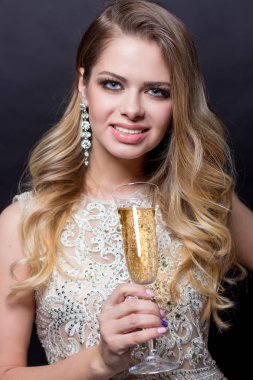 Bir kadeh şampanya ile güzel bir genç kadın portresi. Bir parti. Kutlama. Noel, yeni yıl, doğum günü. Mutlu kadın