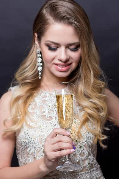 Portrait of a beautiful young woman with a glass of champagne. A party. Celebration. Christmas, New Year, Birthday. Happy woman — Stock Photo, Image