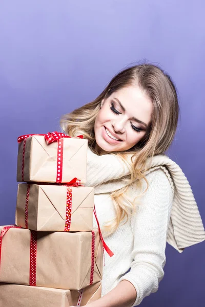 Jovem mulher bonita segurando presentes. Menina feliz segurando presentes em um fundo roxo. Ano Novo. No Natal. Aniversário . — Fotografia de Stock