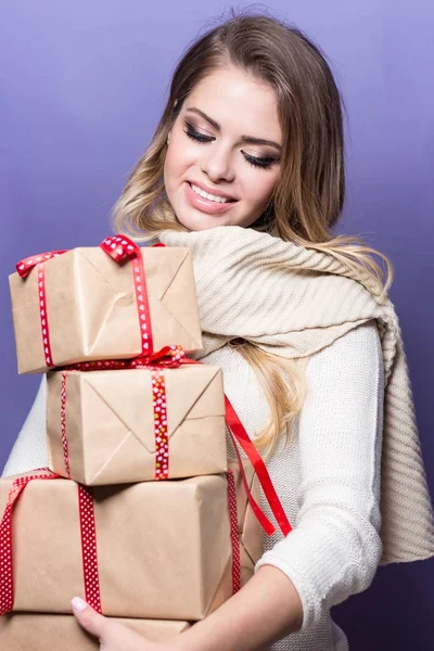 Jovem mulher bonita segurando presentes. Menina feliz segurando presentes em um fundo roxo. Ano Novo. No Natal. Aniversário . — Fotografia de Stock