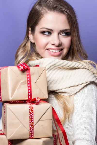 Jovem mulher bonita segurando presentes. Menina feliz segurando presentes em um fundo roxo. Ano Novo. No Natal. Aniversário . — Fotografia de Stock