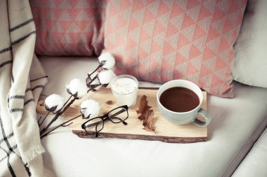 Sonbahar rahat kahvaltı. Romantik kahvaltı. Pamuk, bir fincan sıcak kahve, bir mum, bir ekose, gözlük. Sonbahar zevkli. Bir tepsi ile