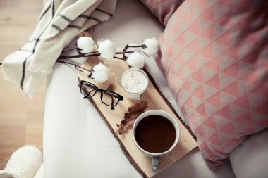 Sonbahar rahat kahvaltı. Romantik kahvaltı. Pamuk, bir fincan sıcak kahve, bir mum, bir ekose, gözlük. Sonbahar zevkli. Bir tepsi ile