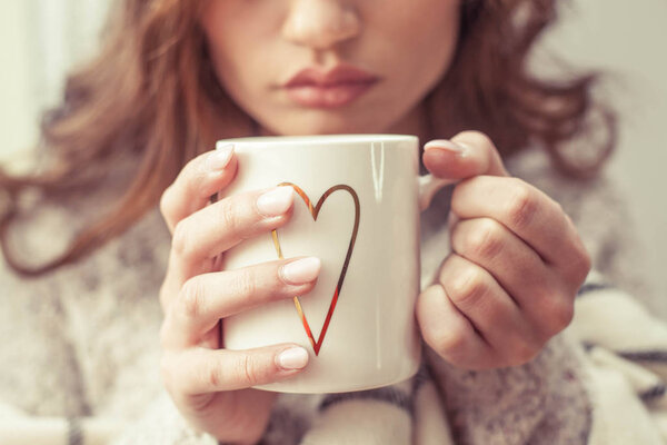 Женские руки держат горячую чашку кофе. Молодая женщина ukutannaja в клетчатой держит чашку какао. Праздники. Уютная осень. Падение
.