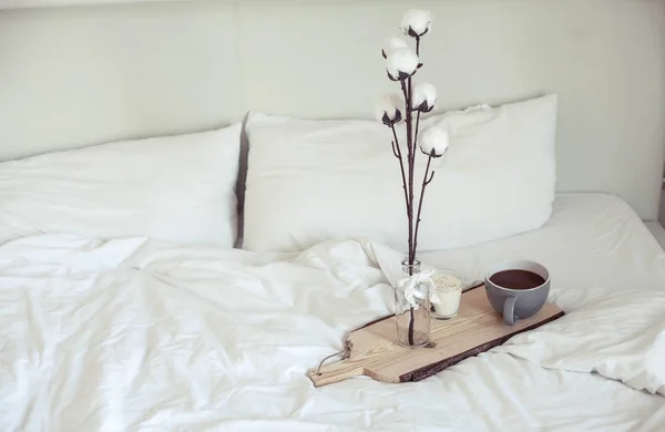 Herfst gezellig ontbijt op bed. Romantische ontbijt. Katoen, een kopje warme koffie, een kaars. Herfst gezelligheid. Een lade met ontbijt is op het bed. Val. — Stockfoto