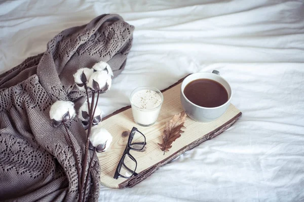 Otoño acogedor desayuno en la cama. Desayuno romántico. Algodón, una taza de café caliente, una vela. Confort otoñal. Una bandeja con desayuno está en la cama. Caída . — Foto de Stock