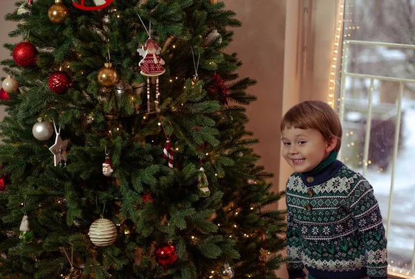 Un mignon petit garçon habille un sapin de Noël. Décor de Noël, nouvel an. L'humeur de Noël. Des vacances. Confortable . — Photo