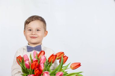 Bir buket çiçek tutan şirin ufaklık. Lale. Anneler günü. Uluslararası Kadınlar Günü. Mutlu bir çocuğun portresi