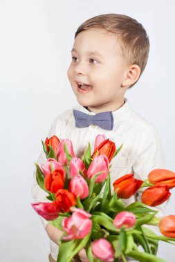 Bir buket çiçek tutan şirin ufaklık. Lale. Anneler günü. Uluslararası Kadınlar Günü. Mutlu bir çocuğun portresi