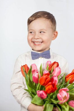 Bir buket çiçek tutan şirin ufaklık. Lale. Anneler günü. Uluslararası Kadınlar Günü. Mutlu bir çocuğun portresi