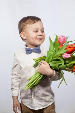 Bir buket çiçek tutan şirin ufaklık. Lale. Anneler günü. Uluslararası Kadınlar Günü. Mutlu bir çocuğun portresi