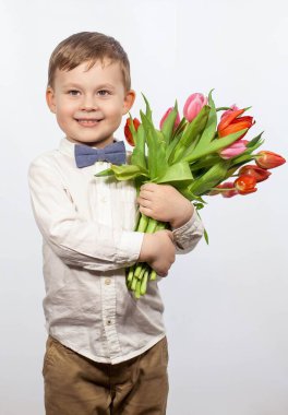 Bir buket çiçek tutan şirin ufaklık. Lale. Anneler günü. Uluslararası Kadınlar Günü. Mutlu bir çocuğun portresi