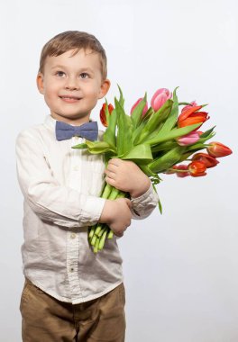 Bir buket çiçek tutan şirin ufaklık. Lale. Anneler günü. Uluslararası Kadınlar Günü. Mutlu bir çocuğun portresi