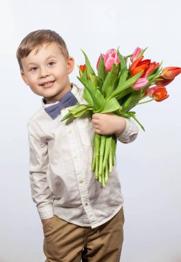 Bir buket çiçek tutan şirin ufaklık. Lale. Anneler günü. Uluslararası Kadınlar Günü. Mutlu bir çocuğun portresi