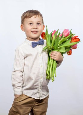 Bir buket çiçek tutan şirin ufaklık. Lale. Anneler günü. Uluslararası Kadınlar Günü. Mutlu bir çocuğun portresi