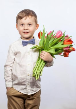 Bir buket çiçek tutan şirin ufaklık. Lale. Anneler günü. Uluslararası Kadınlar Günü. Mutlu bir çocuğun portresi