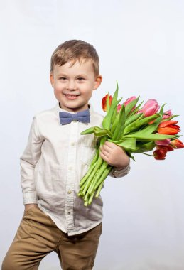 Bir buket çiçek tutan şirin ufaklık. Lale. Anneler günü. Uluslararası Kadınlar Günü. Mutlu bir çocuğun portresi