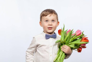 Bir buket çiçek tutan şirin ufaklık. Lale. Anneler günü. Uluslararası Kadınlar Günü. Mutlu bir çocuğun portresi