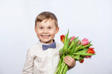 Bir buket çiçek tutan şirin ufaklık. Lale. Anneler günü. Uluslararası Kadınlar Günü. Mutlu bir çocuğun portresi