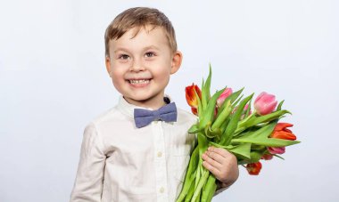 Bir buket çiçek tutan şirin ufaklık. Lale. Anneler günü. Uluslararası Kadınlar Günü. Mutlu bir çocuğun portresi