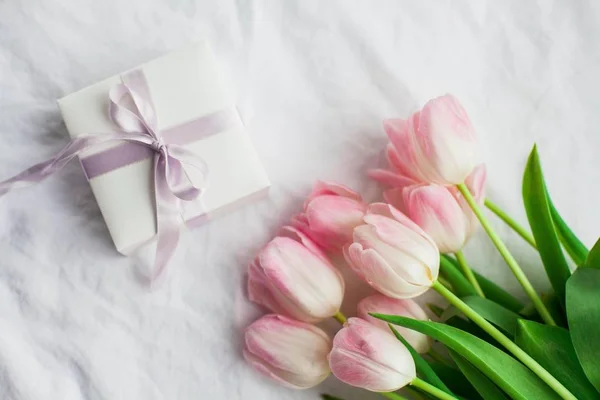Hermosa ropa interior de encaje. Cosméticos, decoraciones, un ramo de tulipanes. Un regalo. Una caja con un regalo. Día Internacional de la Mujer. Vacaciones. Primavera . — Foto de Stock