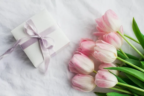 Schöne Spitzenunterwäsche. Kosmetik, Dekorationen, ein Strauß Tulpen. Geschenk. eine Schachtel mit einem Geschenk. Weltfrauentag. Urlaub. Frühling. — Stockfoto