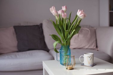 İç. Lale bir cam vazo, sıcak çay, bir mum bir buket bir sehpa üzerinde durmak. Oda. Rahat. Kanepe.