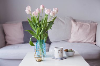 İç. Lale bir cam vazo, sıcak çay, bir mum bir buket bir sehpa üzerinde durmak. Oda. Rahat. Kanepe.