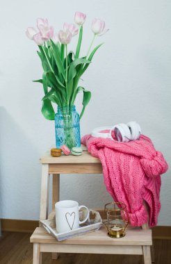 Ev dekorasyon. Rahat dekor. Bir buket Lale ile güzel bir kazak, bir mum stand ahşap bir Kaide üzerine ördü. Bahar. Doğum günü, özel günler, anneler günü. Dünya Kadınlar Günü.