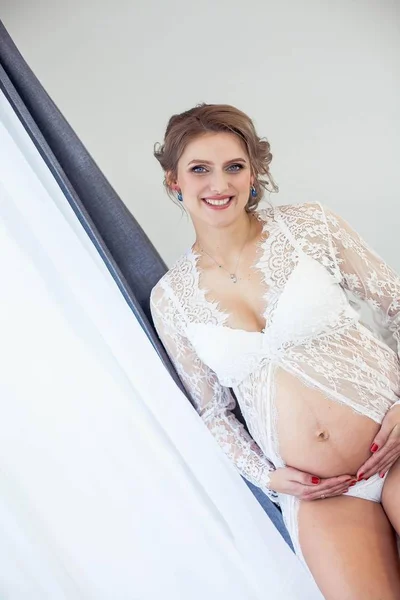 Jovem bela mulher grávida em lingerie rendas descansando em casa. Aconchegante. Retrato de uma jovem mulher grávida feliz. Gravidez. Maternidade . — Fotografia de Stock