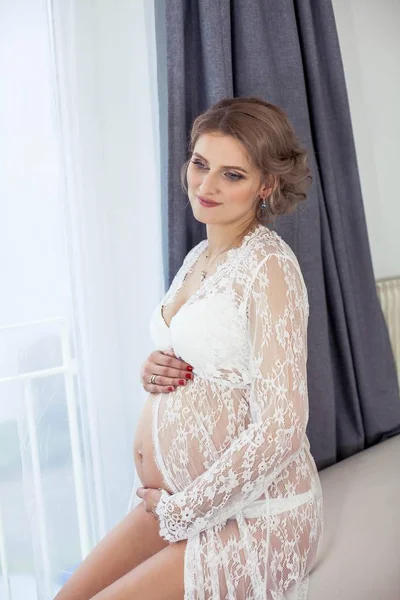 Tânără frumoasă femeie însărcinată în lenjerie de dantelă odihnindu-se acasă. Confortabil. Portretul unei tinere gravide fericite. Sarcina. Maternitate . — Fotografie, imagine de stoc