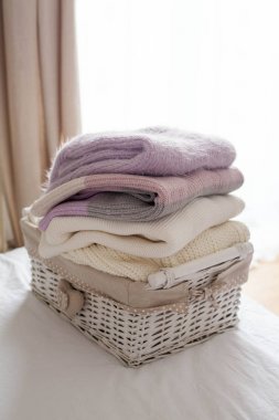 Bir sepet yatakta temiz şeylerle. Rahat. Örme kazak.