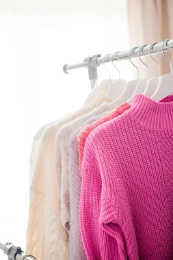 Bir askı şeylerle. Örme kazak askı asmak. Parlak kazak. Bahar kıyafetleri. Moda. Rahat. Ana sayfa.