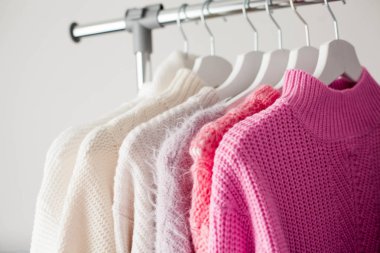 Bir askı şeylerle. Örme kazak askı asmak. Parlak kazak. Bahar kıyafetleri. Moda. Rahat. Ana sayfa.