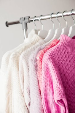 Bir askı şeylerle. Örme kazak askı asmak. Parlak kazak. Bahar kıyafetleri. Moda. Rahat. Ana sayfa.