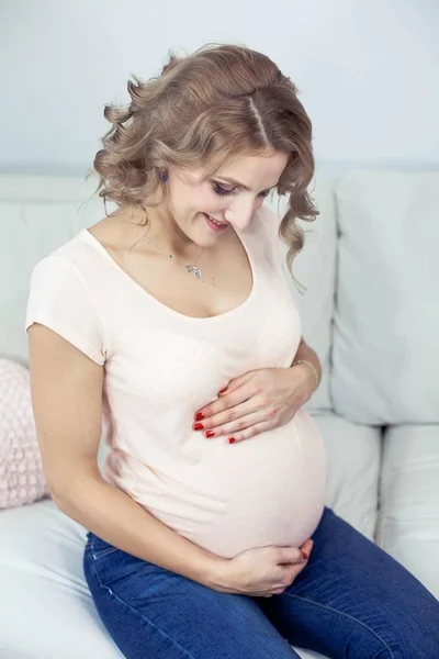 Giovane bella donna incinta sta riposando a casa. Accogliente. Una giovane donna è in piedi vicino alla finestra. Gravidanza. Maternità . — Foto Stock