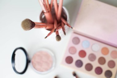 Kozmetik. Makyaj. Tuvalet Masası. Ev dekorasyonu. Mum, göz farı, makyaj fırçaları, ruj, toz. Parlaklık. Pembe altın. Makyaj araçları. Rahat.