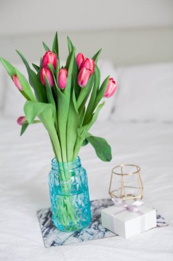 Ev iç. Yatak odası. Bir buket Lale bir cam vazo, bir mum, bir tepsi, bir kutu bir hediye ile yatağa hazır. Sabah. Bahar. Yaz. Tatil. Uluslararası Kadınlar Günü. Anneler günü.